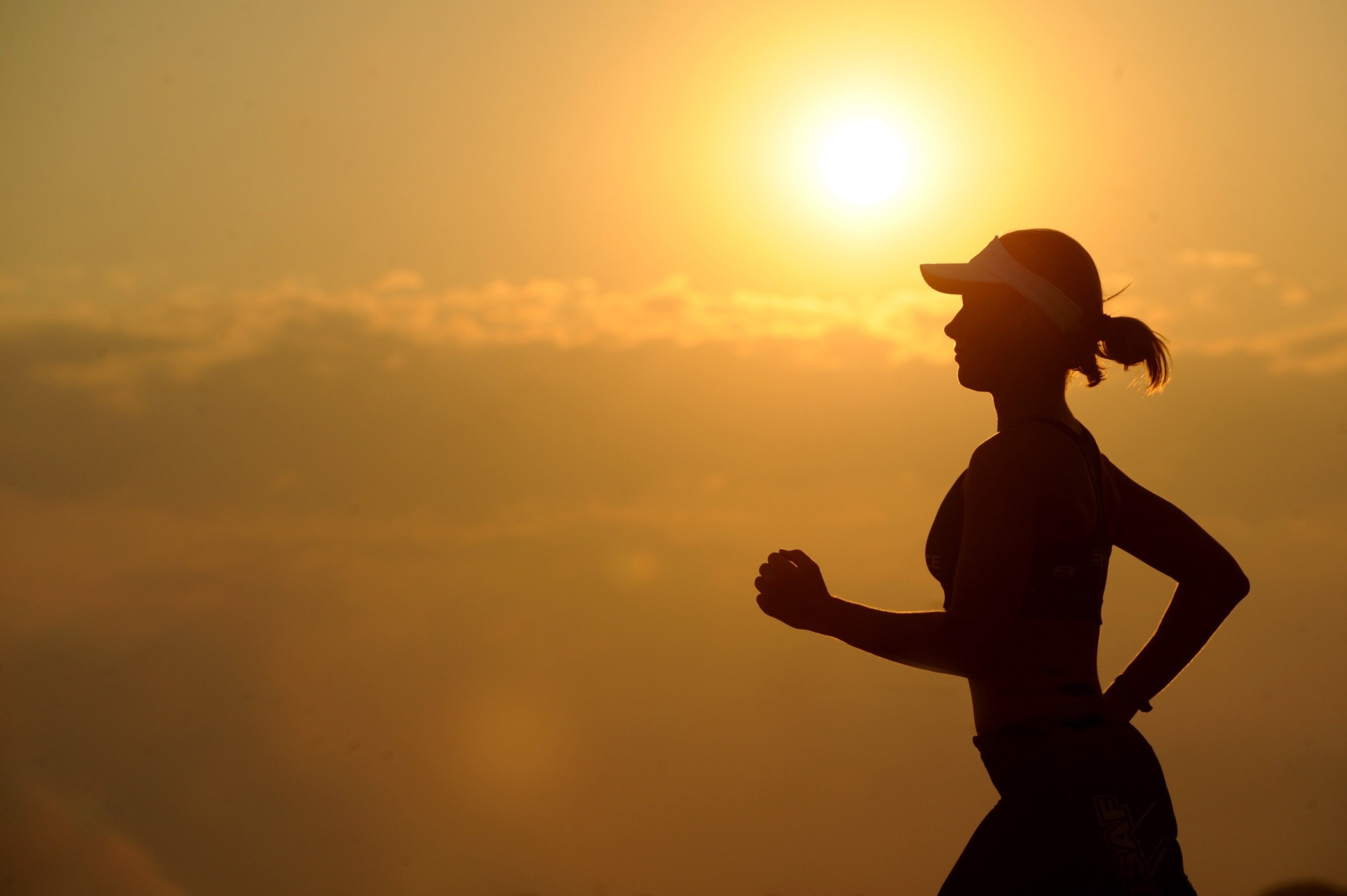 Kvinna springer i solnedgång